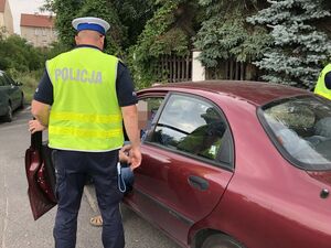 Policjant otwiera drzwi kierowcy