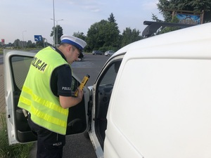 Policjant RD rozmawia z kierowcą trzymając w reku alcoblow