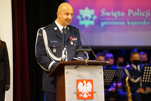 Komendant policji przemawiający na mównicy.