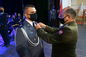 Policjant otrzymuje odznaczenie od Szefa jednostki wojskowej.