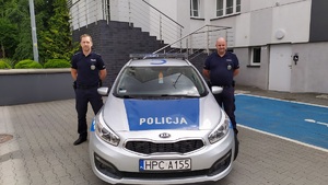 Policjanci przy radiowozie.