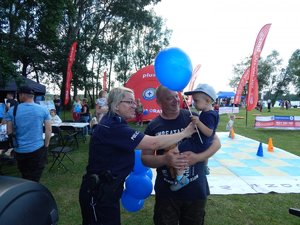 Policjantka daje balon dziecku.