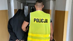 Policjant prowadzi zatrzymanego mężczyznę