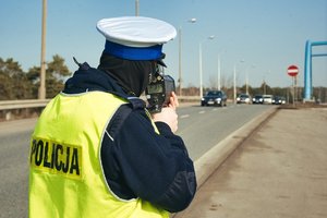 Policjant mierzący prędkość na drodze.