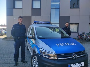 Policjanci, którzy uratowali wędkarza stoją obok radiowozu