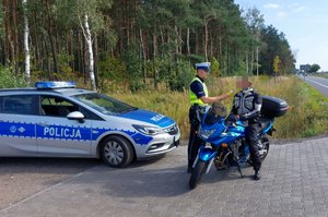 Policjant wykonuje badanie stanu trzeźwości na kierowcy motocyklu