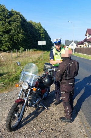 Policjant wykonuje badanie stanu trzeźwości na kierowcy motocyklu