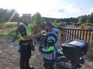 Policjant wykonuje badanie stanu trzeźwości na kierowcy motocyklu