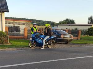 Policjant wykonuje badanie stanu trzeźwości na kierowcy motocyklu