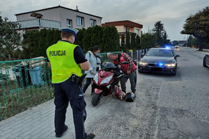 Policjant kontroluje zatrzymany skuter
