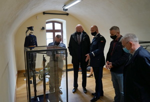 Komendant Wojewódzki Policji w Bydgoszczy oraz Prezydent Torunia i inni zaproszeni goście podczas oglądania eksponatów wystawy w sali muzeum.