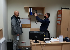 Policjant fotografuje poborowego.