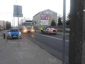 Policjanci kontrolują dwa samochody na ulicy