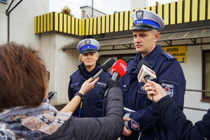 dwoje policjantów rozmawiają z dziennikarzami