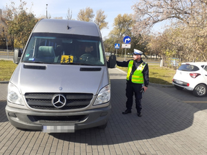 Policjant kontroluje kierowcę busa