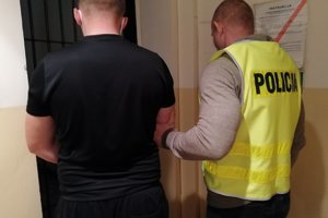 Policjant prowadzi zatrzymanego mężczyznę