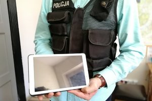Policjant trzyma w dłoni odzyskany tablet