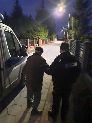 Policjant trzyma za rękę zaginionego mężczyznę