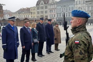 Przedstawiciele służb mundurowych i instytucji rządowych stoją w szeregu na przeciwko żołnierza