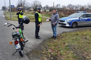 Jeden z policjantów rozmawia z kierowcą, a drugi mierzy prędkość nadjeżdżającego