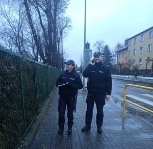 Policjanci idą chodnikiem pod następny adres kwarantannowy