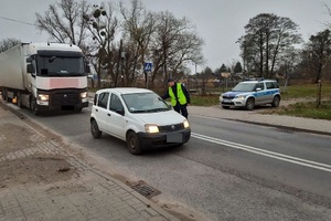 Policjant kontroluje trzeźwość kierowcy fiata, a nim stoi ciężarówka, a obok radiowóz