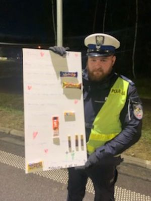 Policjant trzyma kartkę z życzeniami