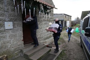 Policjanci wchodzą z prezentami do domu