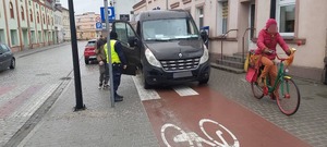 Policjant rozmawia z kierowcą dostawczaka, który źle zaparkował