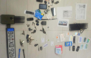 kilkanaście kluczy od pojazdów, niemieckie tablice rejestracyjne, sprzęt elektroniczny, dokumenty, telefony, karty SIM leżą rozłożone na podłodze