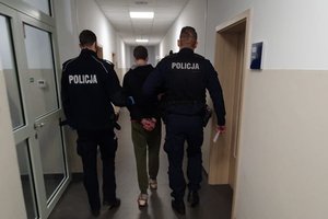 Policjanci prowadzą drugiego z zatrzymanych