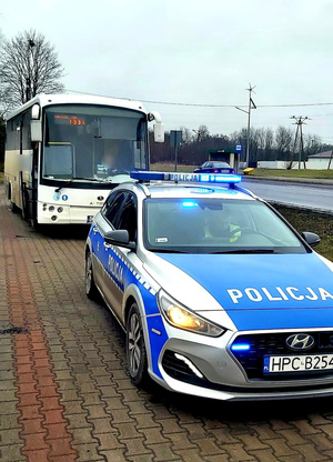 Widok na radiowóz i zatrzymany do kontroli autobus