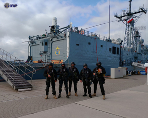 Funkcjonariusze Policji na tle statku.