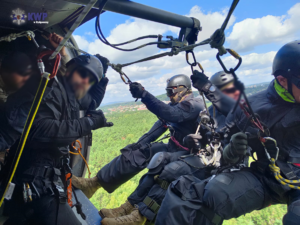 Funkcjonariusze Policji w trakcie przygotowywania się do desantu ze śmigłowca.