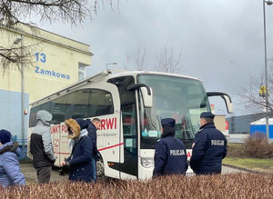 Policjanci przed autobusem.