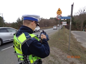 Policjant mierzy prędkość jadących samochodów