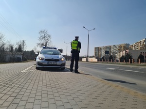 Policjant mierzy prędkość pojazdów na drodze