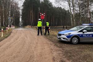 Policjanci kontrolują ruch drogowy przy przejeździe kolejowym