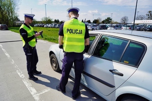 dwóch policjantów kontroluje zatrzymany samochód