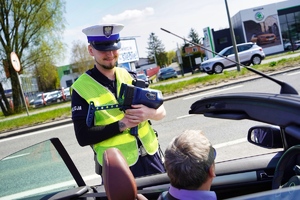 Policjant kontroluje zatrzymany samochód