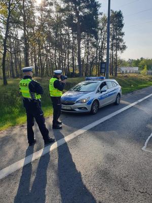 Policjanci mierzą prędkość przy drodze