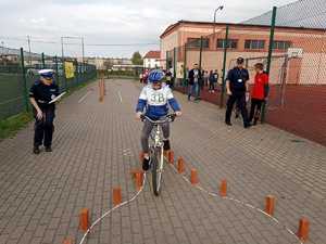 Uczestnik konkursu na rowerze jadący miedzy słupkami.