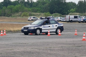 Policjant wyrusza radiowozem, by pokonać tor przeszkód.