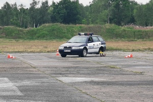 Policjant kieruje radiowozem z zamontowanym trolejem.