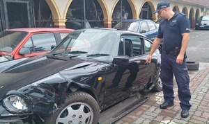 Policjant stoi przy porche