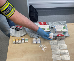 Policjant eksponuje zabezpieczone leki