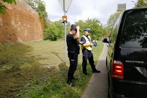 Policjanci stoją przy kontrolowanym pojeździe.