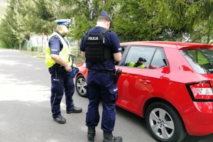 Policjanci podczas kontroli zatrzymanego pojazdu.
