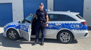 Policjant przy radiowozie.