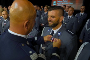 Komendant przypina odznaczenie policjantowi